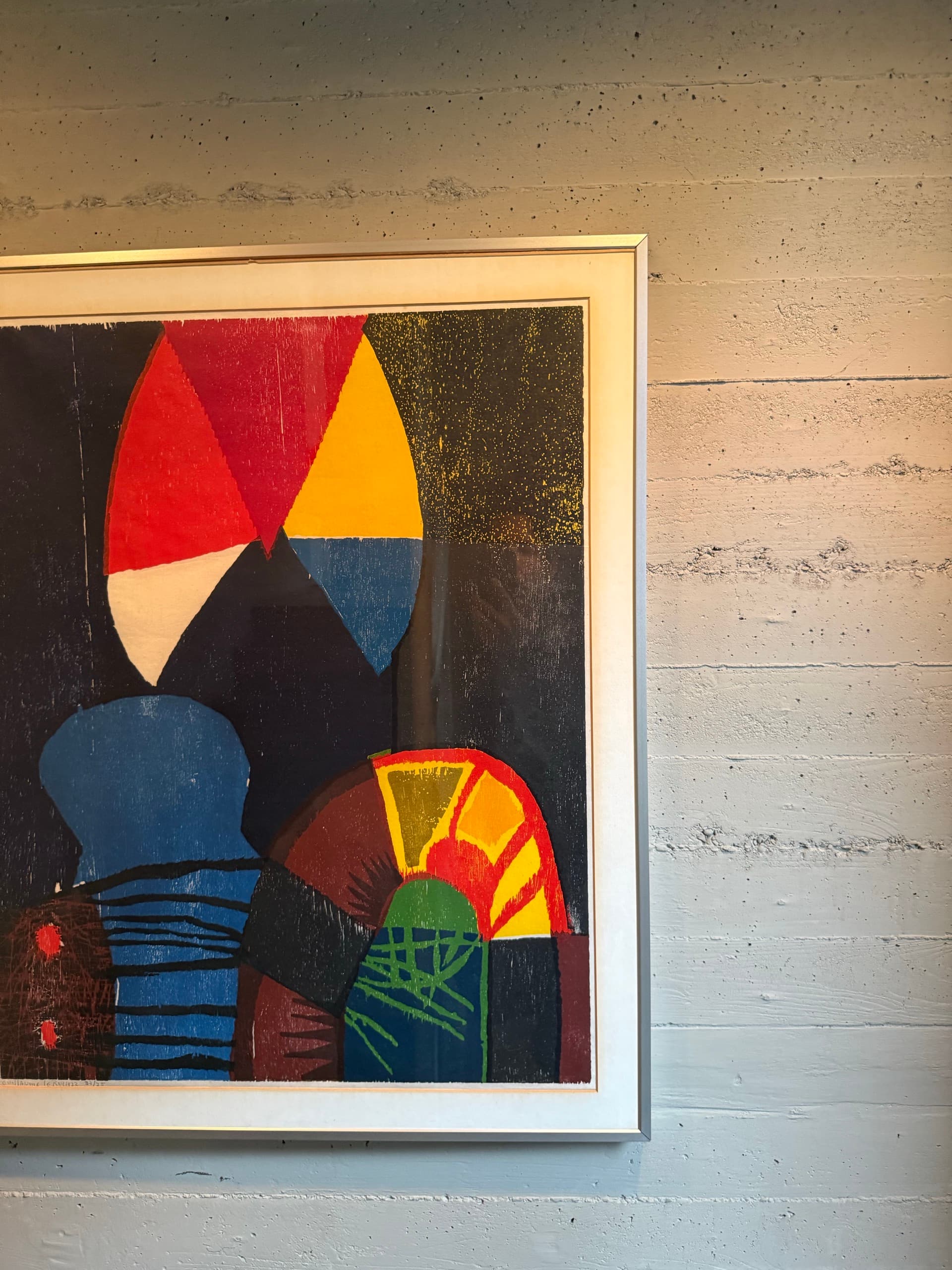 Colorful abstract artwork framed against a concrete wall